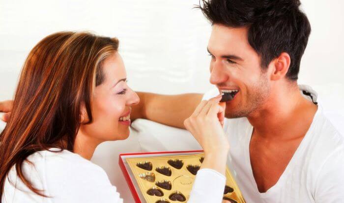 Žena hrani muškarca čokoladom
