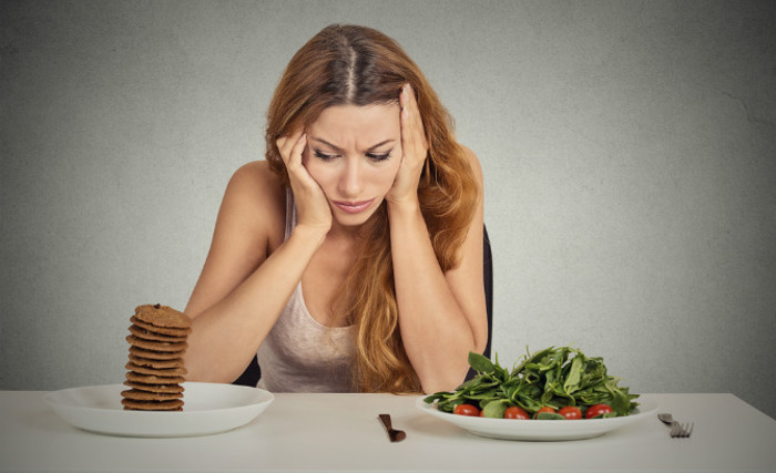 Žena bira između zdrave i nezdrave hrane