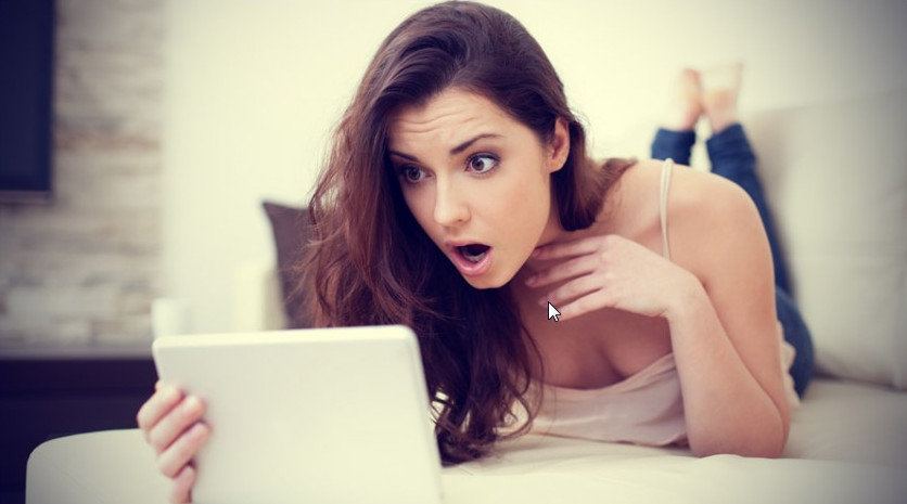 Žena začuđeno gleda u laptop